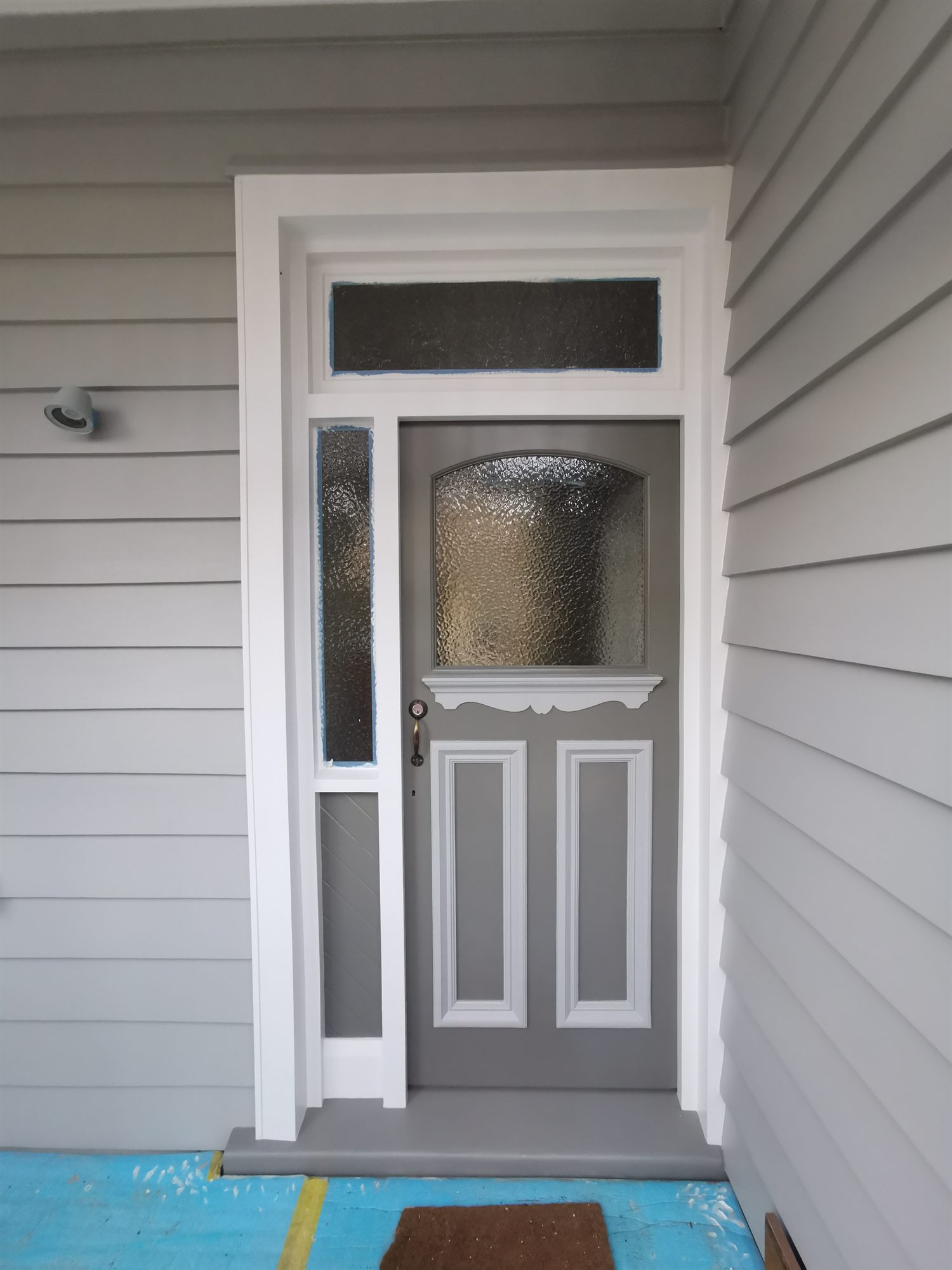 The same front door finished in grey with white panel mouldings, frame and surround.