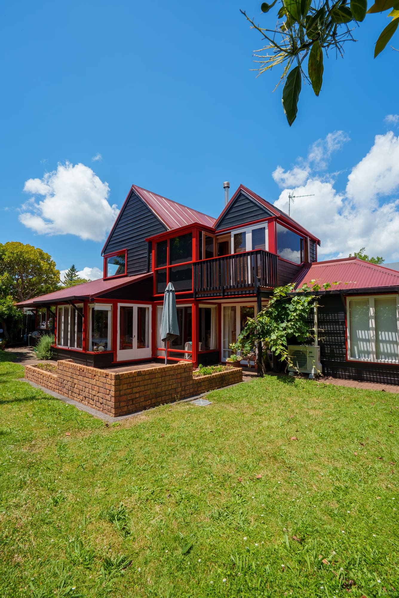 Painted exterior of the Architectural Epsom house, black weatherboard with red trim.