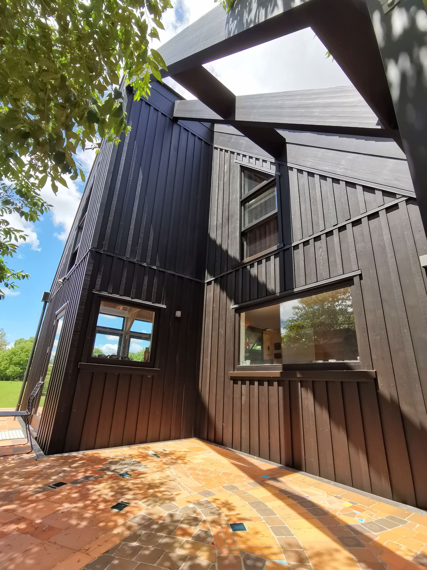 Dark brown stained board-and-batten walls meeting at the entry of a pottery studio.