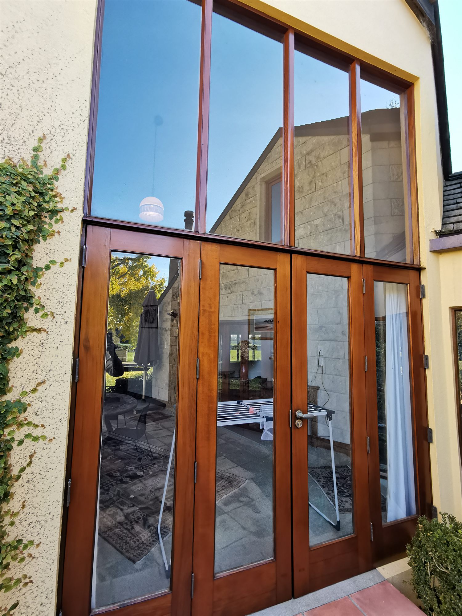 The same gable glazing after stripping and revarnishing, the timber deep and even in the sun.